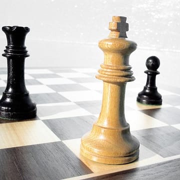 tabuleiro de xadrez com rei branco em check mate e torre e peão preto