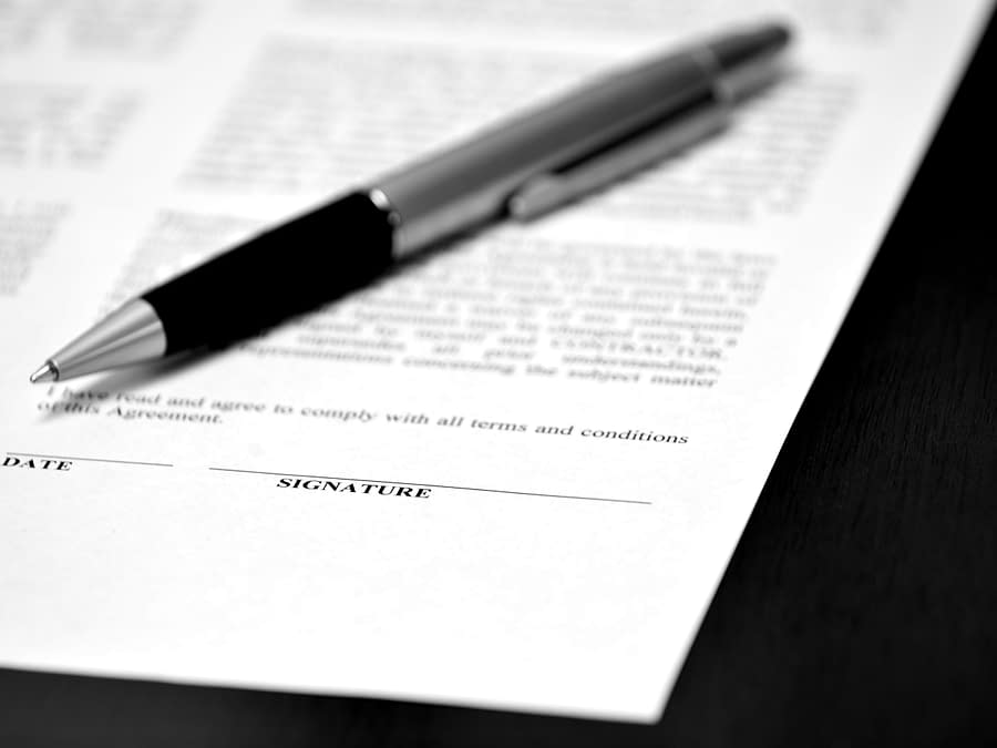 Conferências e Workshops Comerciais contrato com data e assinatura com caneta em cima