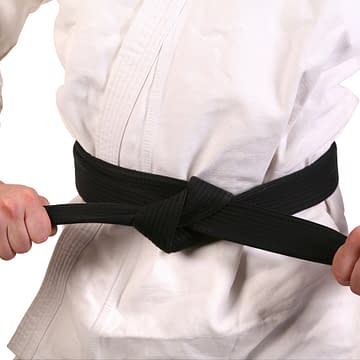 praticante de artes marciais de kimono amarrando a faixa preta